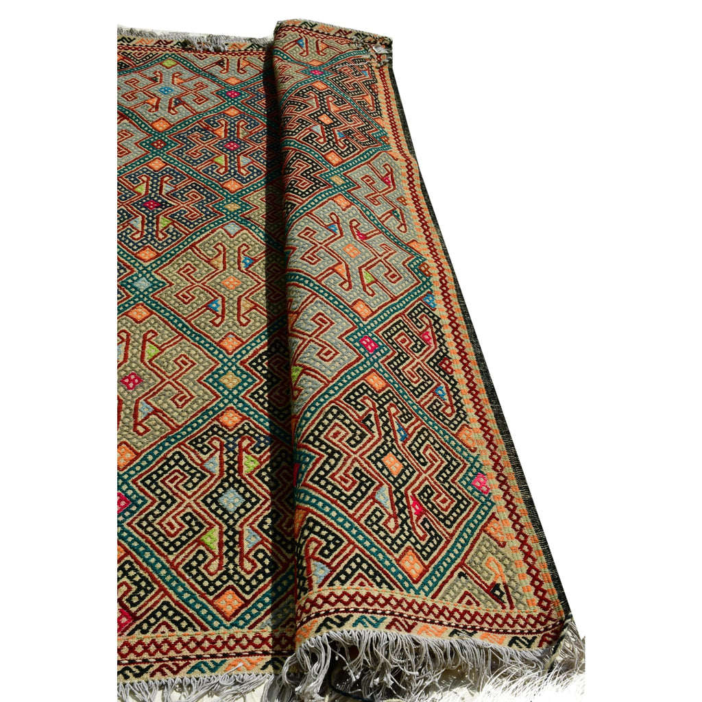 Handmade Afghan Aqcha Wool Rug 5x7 ft propped up showing T-shaped figures and geometric design